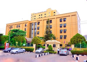 A hotel with a yellow facade, multiple windows, and a sign indicating 'REIZ CONTINENTAL HOTEL'. - Conitnental Exquisite Hotel by Reiz (Abuja)