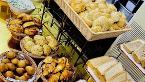 Ein Buffet mit verschiedenen Brotsorten, Gebäck und einem großen Laib Brot.