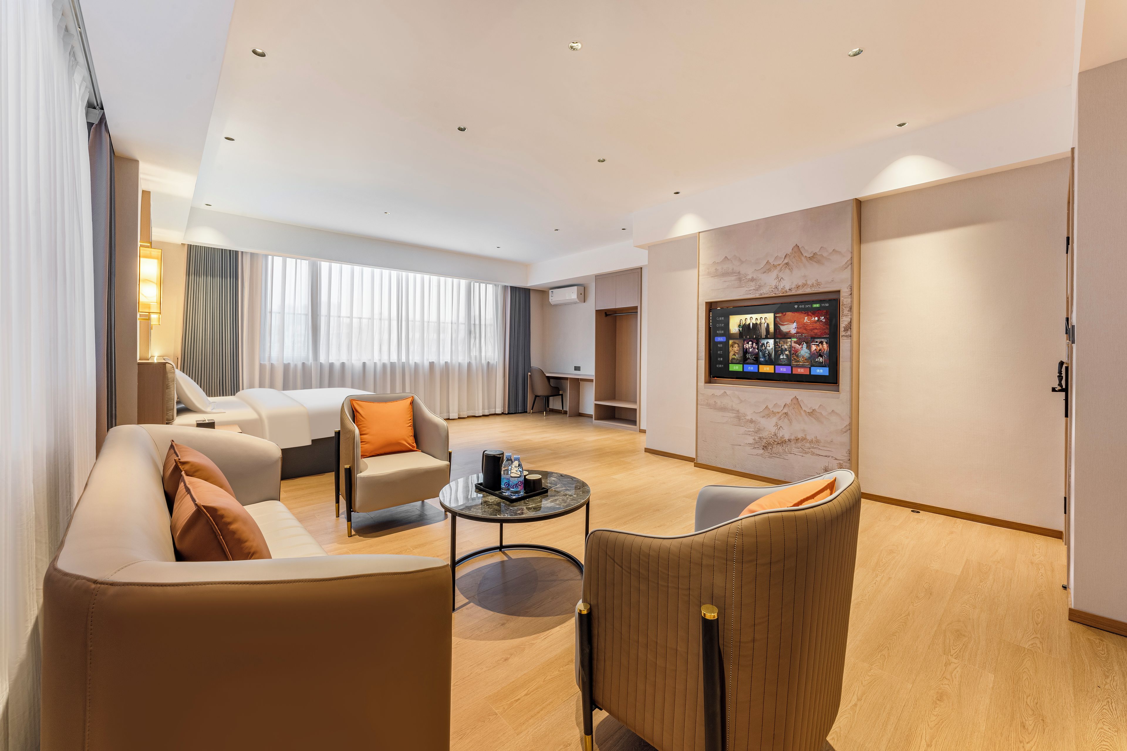 Ein Hotelzimmer mit einer Couch, einem Sessel und einem kleinen Tisch mit Tablett.
