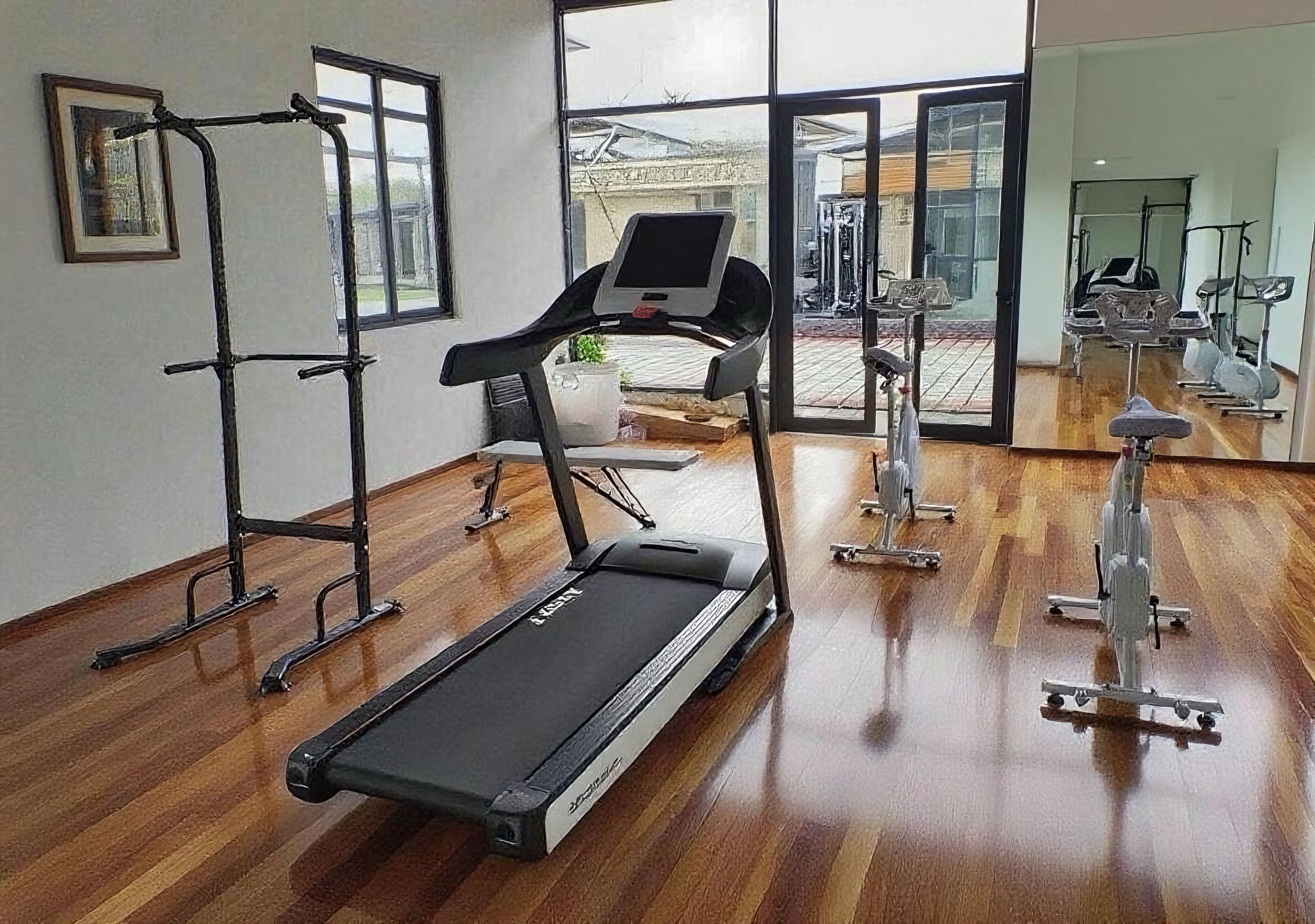 A gym with a treadmill, exercise bike, and weights.