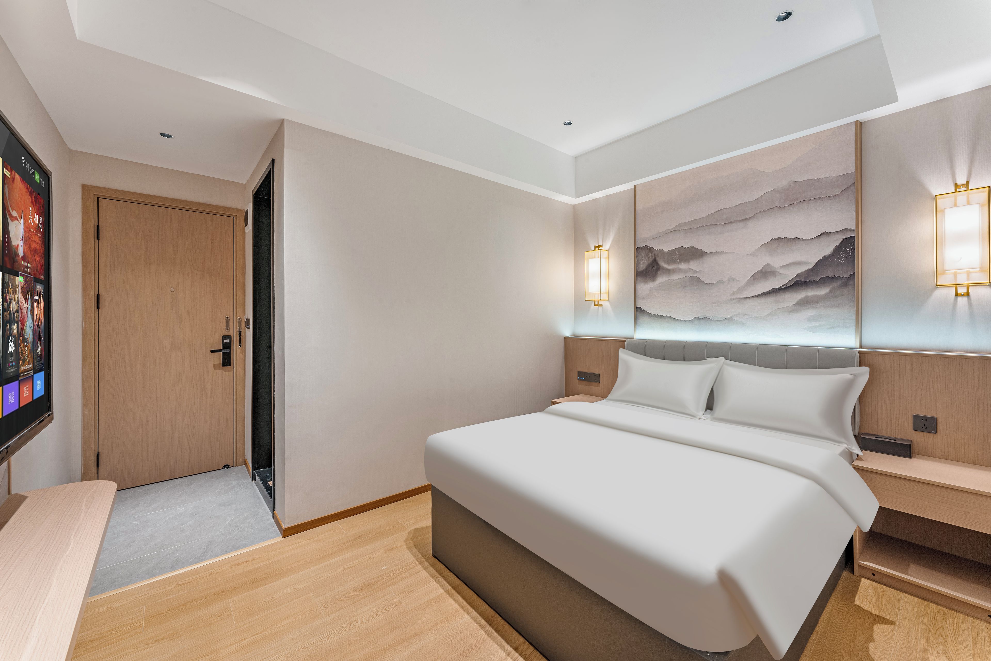 Ein modernes Hotelzimmer mit einem großen Bett, einem Flachbildfernseher und einem Gemälde an der Wand.