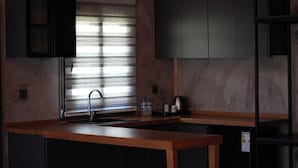 Una cocina con encimera de madera, un lavamanos y armarios.
