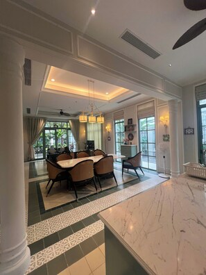 Un comedor amplio con encimera de mármol, ventilador de techo y vistas al exterior.