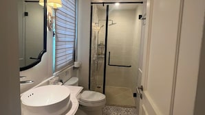A compact bathroom with a white sink, toilet, and a shower area with a glass door. - M Signature Tropical Villas Phu Quoc (Phu Quoc)