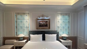 A hotel room with a large bed, two bedside tables with lamps, a ceiling fan, and a framed picture above the bed. - M Signature Tropical Villas Phu Quoc (Phu Quoc)