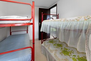 Un dormitorio con literas, una puerta y una ventana.