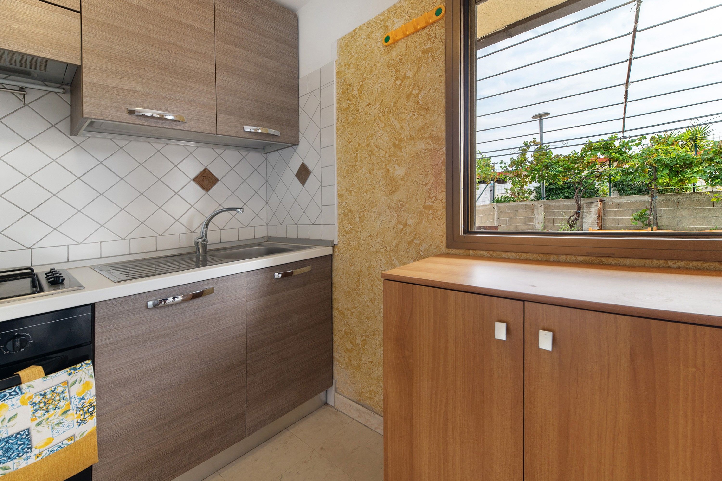 A kitchen with a window, a sink, and cabinets.