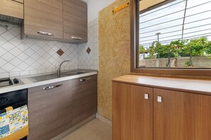 Una cocina con ventana, pileta y alacenas.