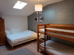 A room with a bunk bed, a single bed, a wardrobe, a skylight, and wall art. - La Maison du Bonheur 20 -seat (Plassac)