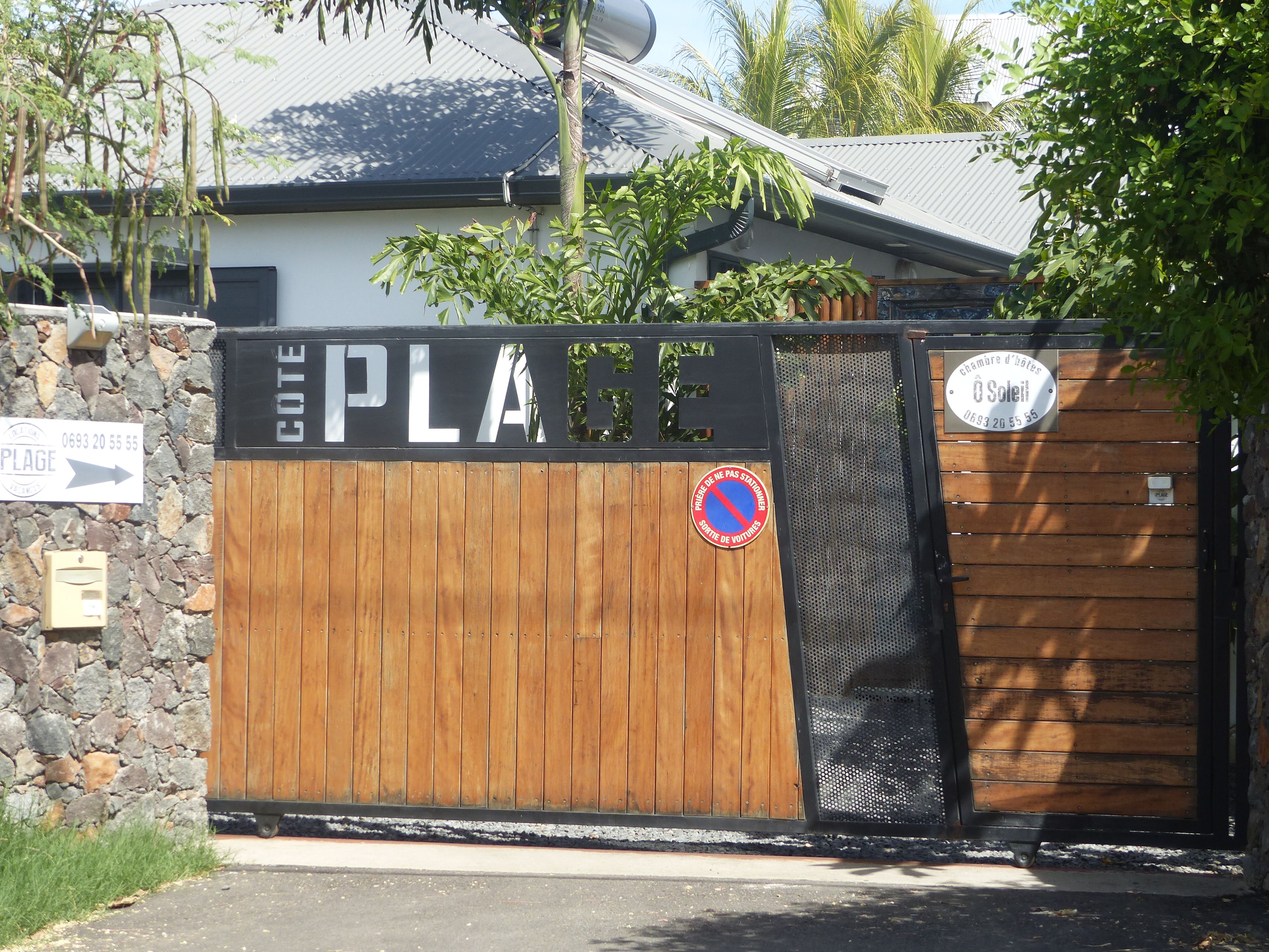 Una entrada con portón y un letrero que dice 'COTE PLAGE' y un letrero de 'prohibido estacionar'.