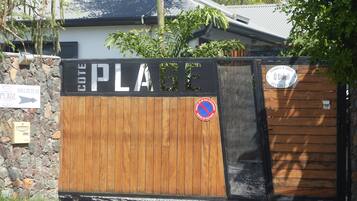 Una entrada con portón y un letrero que dice 'COTE PLAGE' y un letrero de 'prohibido estacionar'.