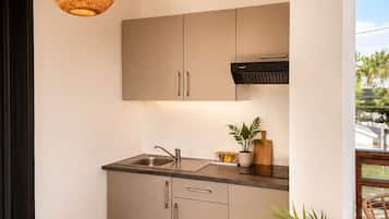Eine moderne Küche mit Einbauherd, Spüle und einem Holzessttisch mit einem Stuhl.