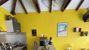 A kitchen with a dining table, chairs, and a hanging light fixture. - Vrbo Property (Le Diamant)