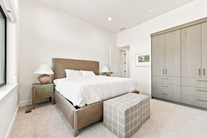 A bedroom with a bed, bedside tables, a wardrobe, and a window. - Everpine Haus | Exclusive Tamarack Perks (Tamarack)