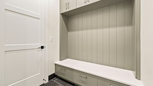 A walk-in closet with a white door, a countertop, and a set of drawers.