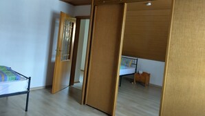 Una habitación con una cama, una mesita y una puerta corredera.