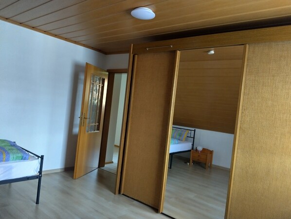 A room with a bed, a small table, and a sliding door.