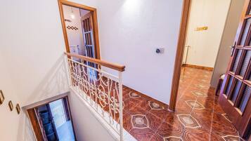 A staircase with a white railing and patterned floor tiles.