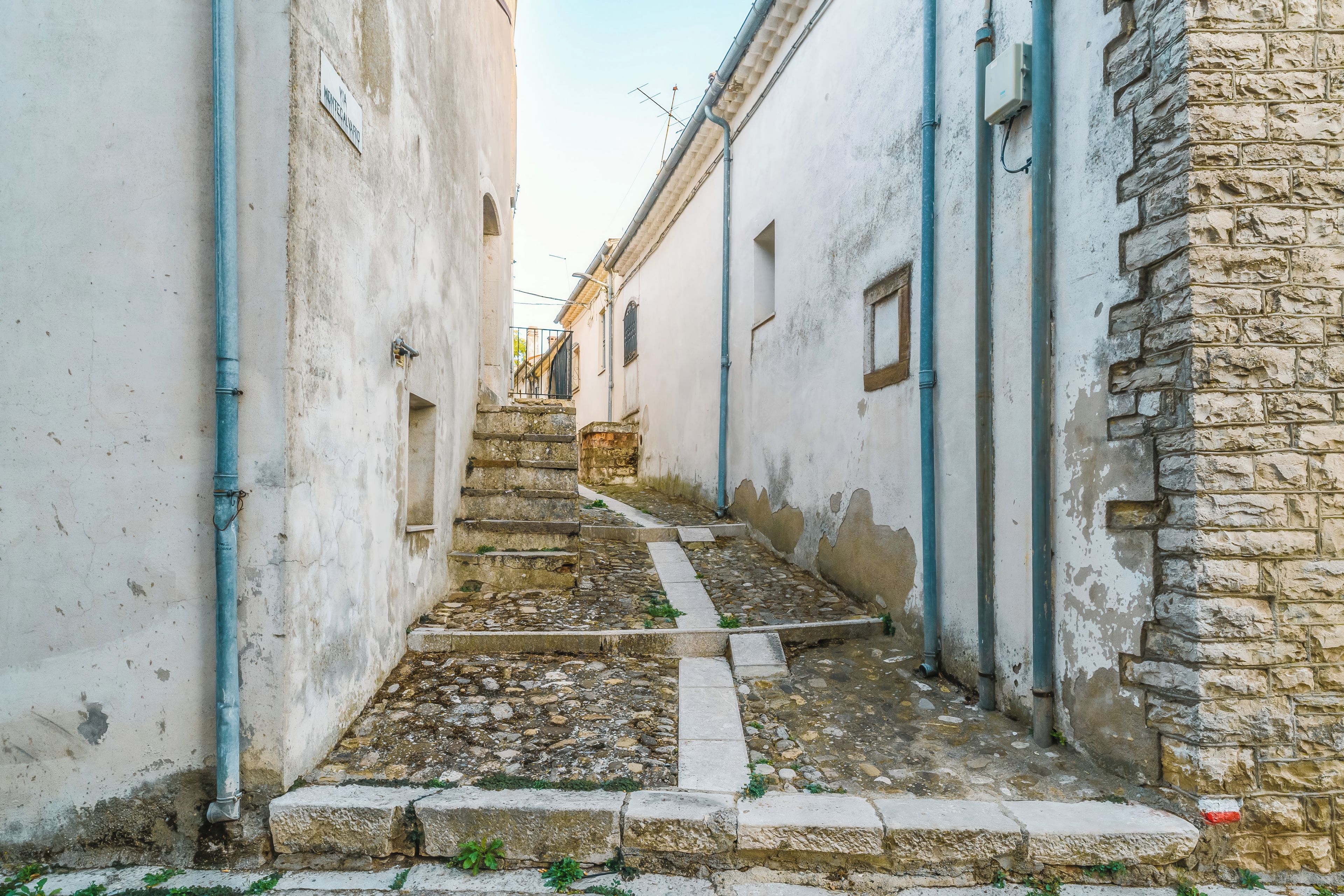 Un estrecho callejón con escalones de piedra que conducen a la entrada de un edificio.