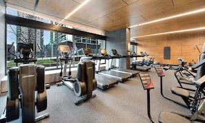 Ein Fitnessstudio mit Cardiogeräten, Kraftstationen und Laufbändern.