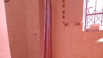 A bathroom with a shower, toilet, and sink.