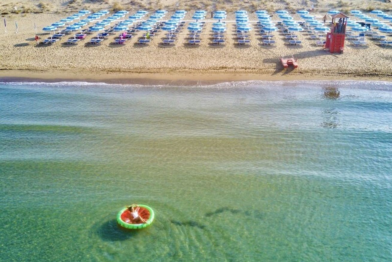 Una spiaggia con file di ombrelloni e una torretta di salvataggio.
