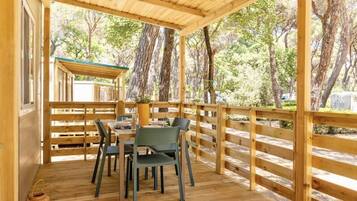 A wooden deck with a table and chairs, surrounded by a wooden railing.
