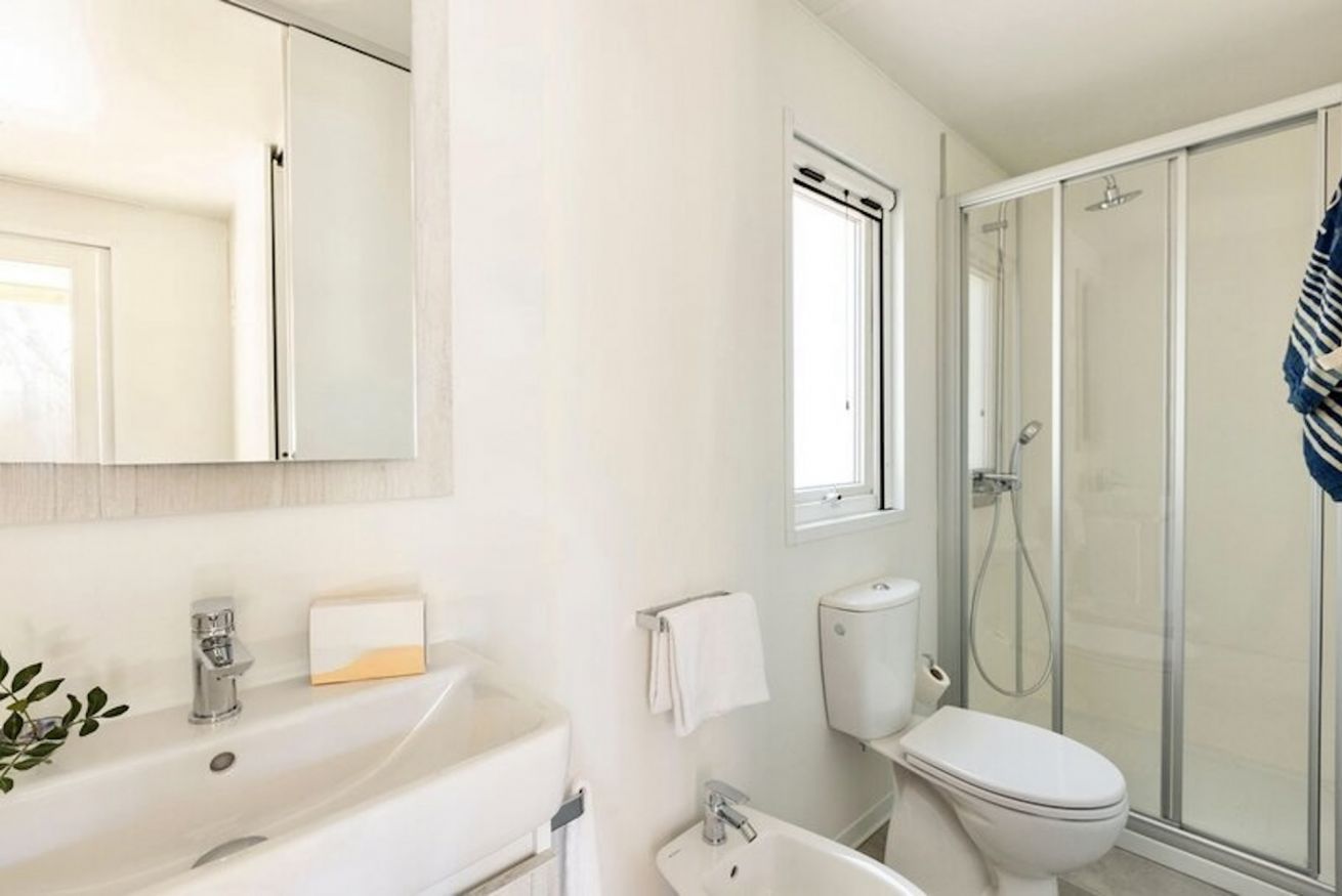 A modern bathroom with a shower, toilet, and sink.