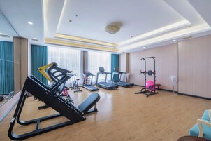 Un gimnasio con equipo de ejercicio, incluyendo cintas de correr y una máquina de pesas.