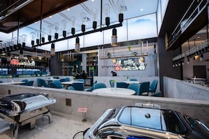 Interior de restaurante con barra, asientos y exhibición de automóviles.