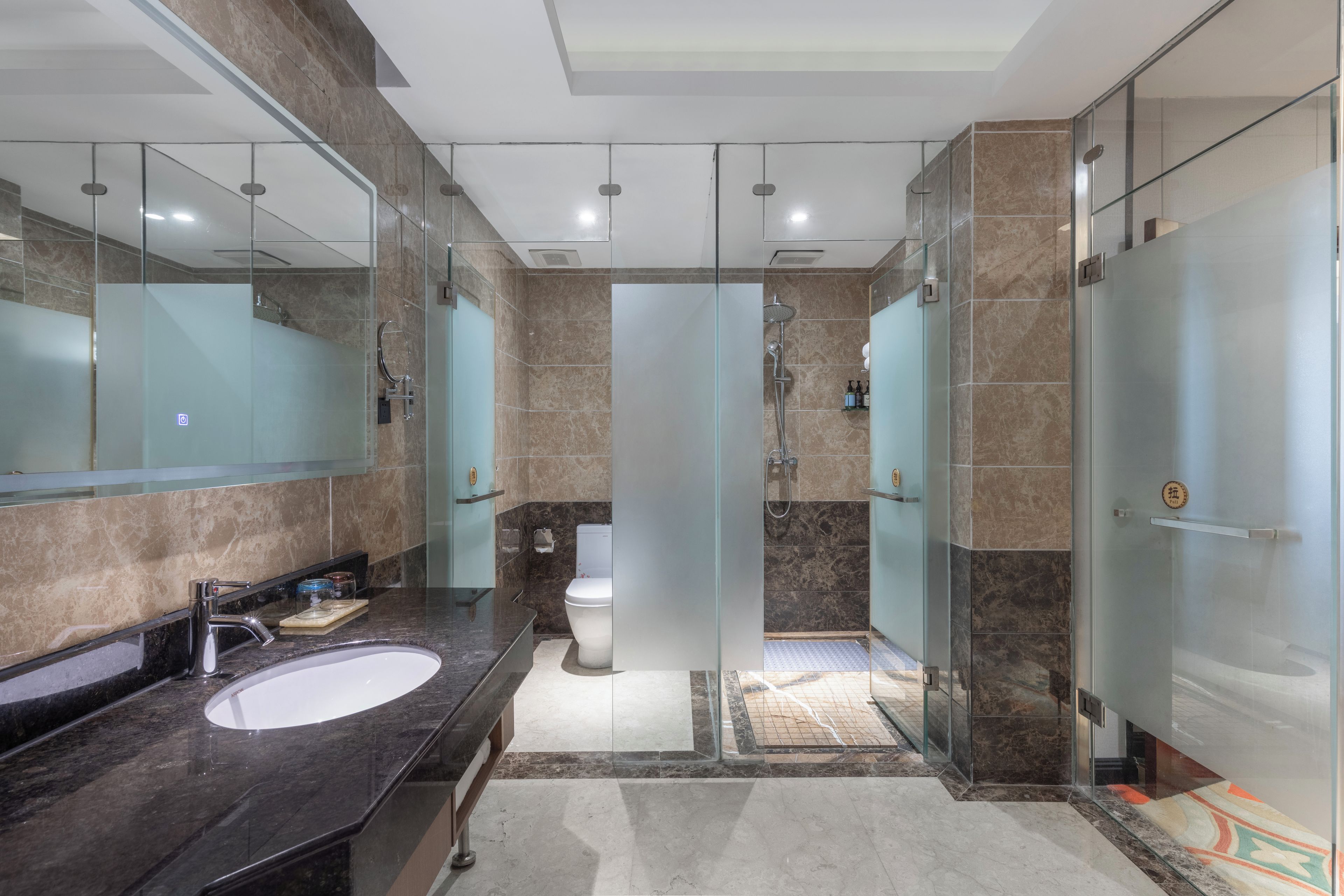 A modern bathroom with a large mirror, a sink, a toilet, and a shower area.