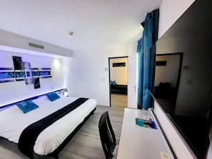 Ein modernes Hotelzimmer mit Bett, Schreibtisch und einem großen Spiegel.