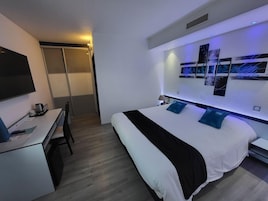 Una habitación de hotel moderna con cama, escritorio y armario corredero.