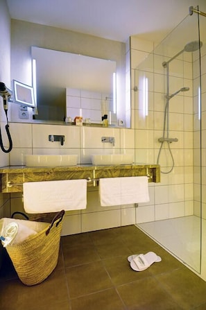 A bathroom with a shower, two sinks, a mirror, and a hairdryer. - Md- Wellnesshotel Gruner Wald (Freudenstadt)