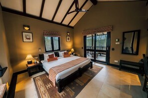 Ein Schlafzimmer mit einem großen Bett, zwei Nachttischen, einem Fenster mit Blick und einem Balkon.