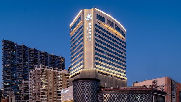 A high-rise hotel with a modern design, featuring a prominent logo on the facade. - Xiamen United Hotel (Xiamen)