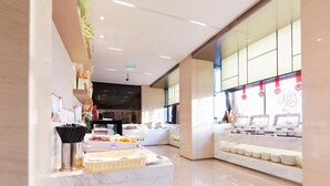 A modern hotel lobby with a marble reception desk, a buffet area, and a large window with red decorations. - Xiamen United Hotel (Xiamen)