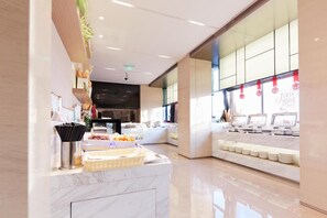 A modern hotel lobby with a marble reception desk, a buffet area, and a large window with red decorations. - Xiamen United Hotel (Xiamen)