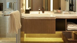 A modern bathroom with a glass shower enclosure, a large mirror, and a vanity with a towel rack. - Xiamen United Hotel (Xiamen)