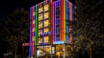 Un edificio de varios pisos con un letrero del hotel 'ZAFRANI DARBAR', que presenta una escalera y una entrada visible.