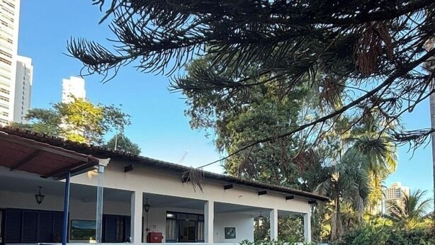 A two-story building with a balcony, a staircase, and a car parked in front. - Pousada Serras De Goyaz (Goiânia)