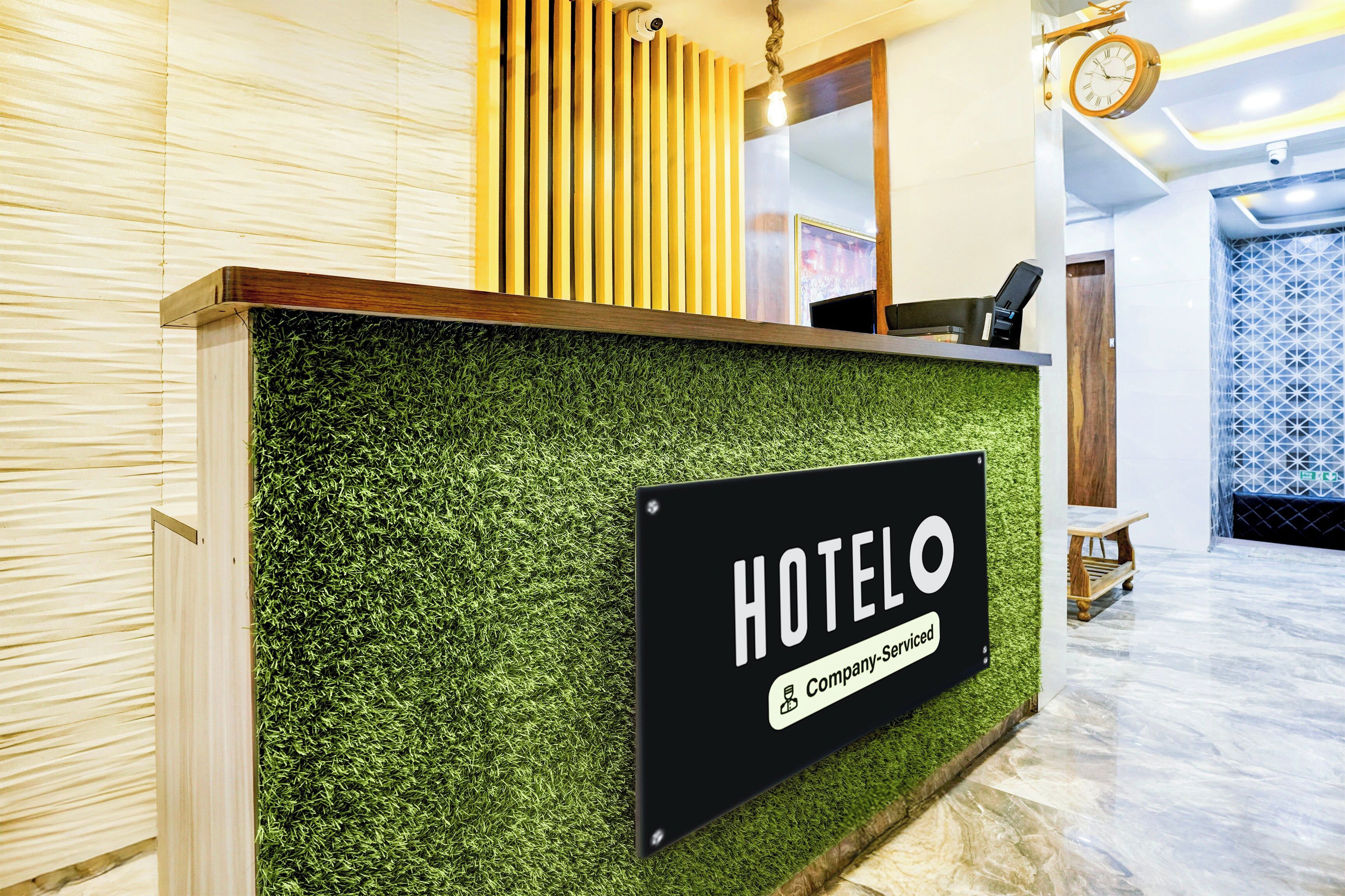 A hotel reception desk with a sign indicating it is company-serviced.