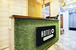 A hotel reception desk with a sign indicating it is company-serviced.