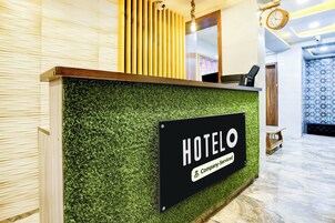 A hotel reception desk with a sign indicating it is company-serviced.