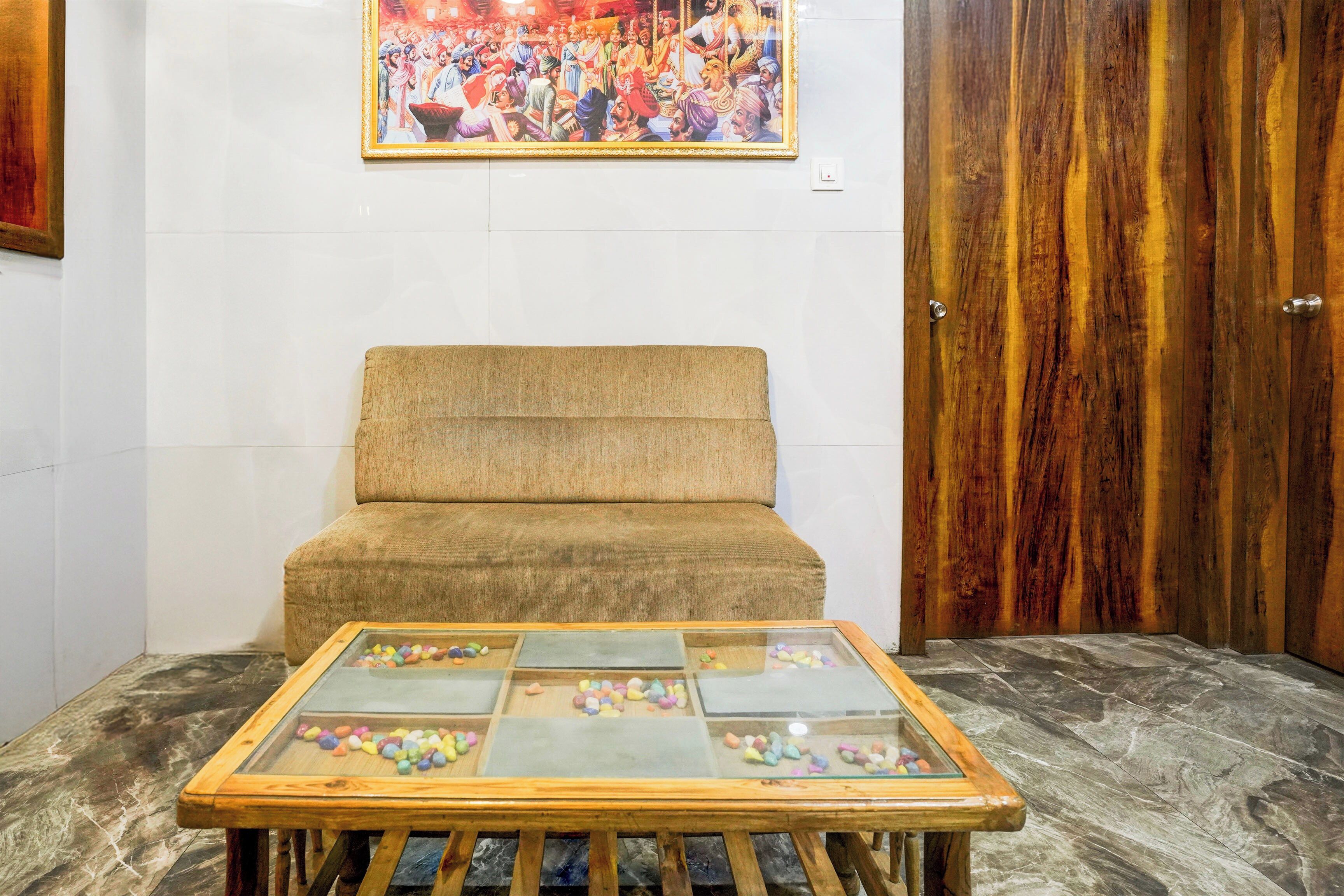 Una habitación con sofá y una mesa de vidrio decorada con guijarros de colores.
