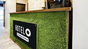 A hotel reception desk with a sign indicating it is a company-serviced hotel. - Hotel O Dombivali Formerly PK Lodging (Kalyan)