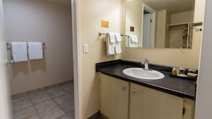 A bathroom with a sink, mirror, and towel rack. - Bcm Inns Fort Mcmurray - Downtown (Fort McMurray)