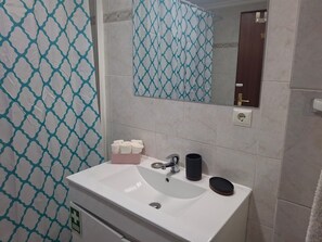 A bathroom with a white sink, a mirror, and a towel rack. - Apartment 'Azenha View' with Sea View, Balcony and Wi-Fi (Caniço)