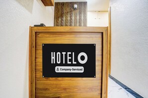 A wooden door with a sign that reads 'HOTELO' and 'Company-Serviced.'