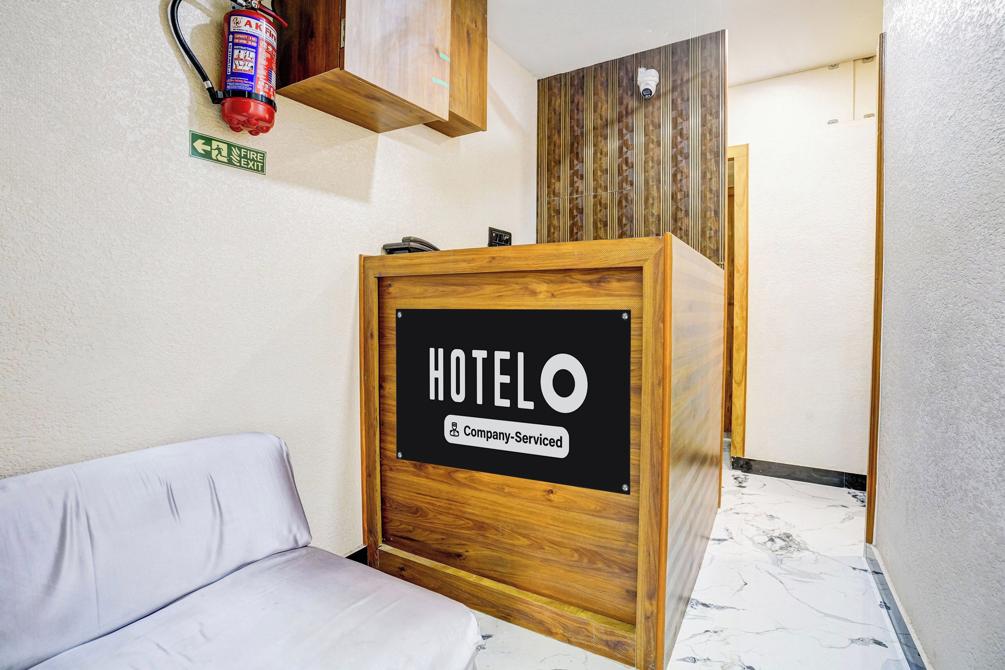 A hotel reception desk with a sign indicating it is company-serviced.